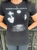 Person wearing a black t-shirt with a Sisters of Mercy Floodland album graphic design and text