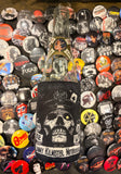 Lemmy Kilmister black coozie featuring a black and white stylized skull image of him with the words 'Born to Lose, Live to Win, Lemmy Kilmister Motorhead' in black text on white banner backgrounds, photographed on top of a bunch of band button pins.