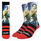 Crew socks featuring an image of Freddie Mercury wearing a white jumpsuit and singing, with red and black stripes on the feet and the word "Freddie" in script.