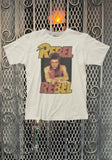 Tan David Bowie Rebel Rebel t-shirt featuring an image of David Bowie wearing a scarf with the words 'Rebel Rebel' in large red and yellow text, on a metal gate background.