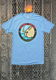 Light blue Butthole Surfers Pee Pee the Sailor t-shirt featuring the album cover artwork on a metal gate background.