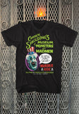 Captain Spaulding's Museum of Monsters black t-shirt featuring an illustration of his head from the movie along with green text for 'Captain Spaulding's Museum of Monsters and Madmen', displayed on a metal gate background.