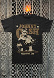 Johnny Cash San Quentin Live black t-shirt featuring performance poster artwork with a sepia image of him with a guitar holding up his middle finger along with the text 'Johnny Cash San Quentin State Prison California 1969', displayed on a metal gate background.
