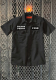 Black work shirt featuring a name patch that says 'Cash' on the left chest and patch with 'Folsom Prison' on the right chest, displayed on a metal gate background.