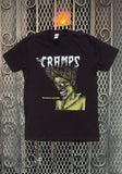 The Cramps Bad Music for Bad People black t-shirt featuring the album artwork, photographed on a metal gate background.