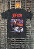 A black short-sleeve graphic t-shirt featuring the band Dio and their 'Holy Diver' album artwork, displayed flat against a metal mesh door background.