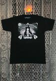Elvira Spirit Board black t-shirt  featuring a black and white image of her holding a crystal ball with spirit board elements around her in the image along with the text 'Elvira Mistress of the Dark Call Me Tonight Later Darling' around the image, displayed against a metal gate background.