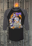 Elvira black raglan t-shirt with dark charcoal heather grey 3/4 sleeves featuring a colorful image of her in a graveyard with the words 'Wish You Were Here' in large script, photographed flat on a metal gate background.