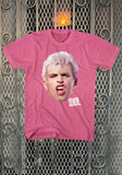 A pink graphic t-shirt featuring a cutout print of Billy Idol with platinum blonde hair and the word 'IDOL' in white text, displayed against a metal gate background.