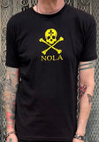 Kulture Vulture Exclusive NOLA black t-shirt with a yellow skull and crossbones with a fleur de lis in the forehead of the skull and 'NOLA' underneath the graphics, photographed on a model in front of a metal gate background.