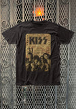 Kiss Vintage Concert Ticket black t-shirt featuring a mock concert ticket from Toledo Ohio on July 31st in a parchment vintage design along with a black and sepia image of the band across the bottom of the ticket, displayed on a metal gate background.