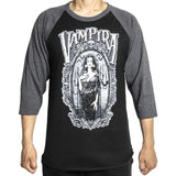 Vampira black raglan t-shirt with dark charcoal heather grey 3/4 sleeves featuring a black and white image of her inside an elaborate frame, on a model against a white background.