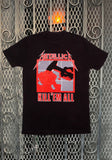 Front of Metallica Kill 'Em All black t-shirt featuring the album artwork, displayed on a metal gate background.
