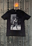 Front of Nine Inch Nails Self Destruct '94 black t-shirt featuring image of Trent singing, photographed on a metal gate background.