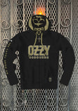 Front of Ozzy Osbourne No More Tours black hooded sweatshirt featuring large 'Ozzy' and smaller 'Osbourne' in gold text with white outlines across the front, the words 'No more tours vol 2' down the right sleeve, and a gold skull illustration inside the hood, displayed on a metal gate background.