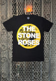 A black short-sleeve t-shirt featuring a large yellow lemon slice graphic with the text 'THE STONE ROSES' in white, displayed against a metal mesh gate background.