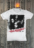 The Stooges Band white t-shirt featuring a black and white image of the band members, photographed flat on a metal gate background.