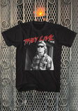 They Live Red Roddy black t-shirt featuring the words 'They Live' in red text with white outline along with a black and white image of Roddy, displayed on a metal gate background.