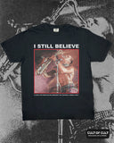Black Lost Boys I Still Believe t-shirt featuring an image of Tim Cappello playing the saxophone, on a black and grey illustration background.
