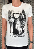 Person wearing a t-shirt with a graphic of Stevie Nicks and text 'Stevie Nicks is my fairy godmother' against a textured wall.