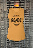 AC/DC High Voltage golden yellow sleeveless t-shirt featuring black lettering for "AC/DC High Voltage", photographed flat on a metal gate background.