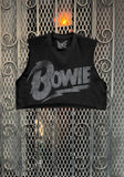 Black Bowie sleeveless crop top t-shirt featuring the Bowie logo in distressed white text, on a metal gate background.