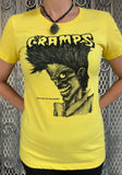The Cramps Bad Music for Bad People yellow t-shirt featuring the album artwork, photographed on a model in front of a metal gate background.