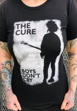 The Cure Boys Don't Cry black t-shirt featuring the album artwork, photographed on a model in front of a metal gate background.