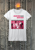 Duran Duran Debut Album white t-shirt featuring the album artwork in shades of pink with the text "Duran Duran" at the top, photographed flat in front of a metal gate background.