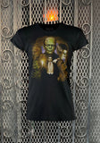 Universal Monsters Color Collage black t-shirt featuring imagery of Frankenstein, Bride of Frankenstein, Wolfman, Dracula, Creature from the Black Lagoon, and Invisible man, photographed flat on a metal gate background.