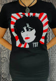 Siouxsie Sioux black t-shirt featuring a black and white illustration of her face with red lips set on a white and red rising sun background and stylized "Siouxsie" in the bottom of the image, photographed on a model in front of a metal gate background.