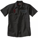 Close-up of black Mortician work shirt featuring a name patch that says 'Mortician' on the left chest and a black and red coffin shaped patch with a cross on the right chest, displayed on a white background.