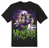 Close-up of Munsters Spooky Family black t-shirt featuring the word 'Musters' in large green dripping text along with a colorful image of the family, displayed on a white background.