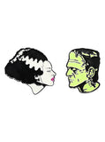 Enamel pin set featuring the heads of Frankenstein in green and his Bride in black and white with pink lips, photographed on a white background.