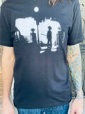 The Cure Exorcist black t-shirt featuring a silhouette of Robert Smith in the style of the Exorcist movie imagery, photographed on a model.