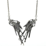 A silver-toned metal pendant necklace featuring Edward Sissorhands hands touching and suspended from a matching chain, photographed on a white background.